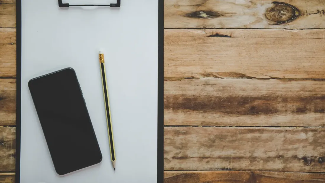 Organized desk workspace with laptop, notebook, and office supplies