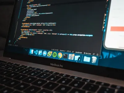 Developer workspace with code editor and project timeline notes on a desk