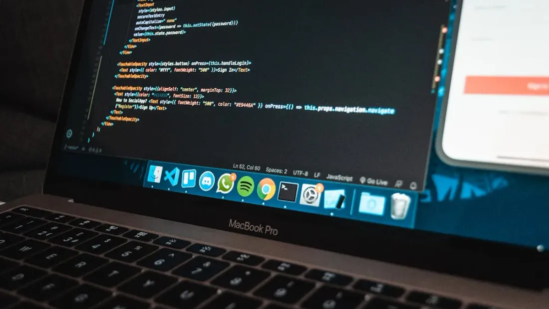 Developer workspace with code editor and project timeline notes on a desk