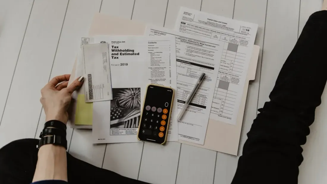 A calculator and laptop on a desk representing website cost planning