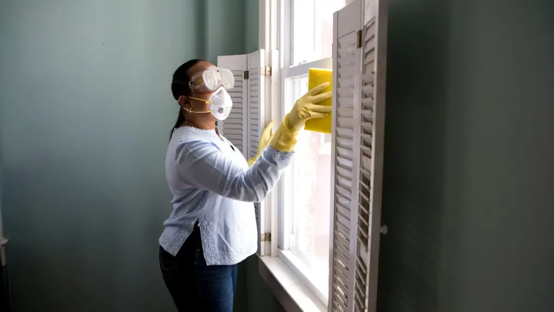 Person cleaning a kitchen counter with professional supplies