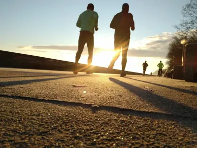 Runners at the start line of a race with red rock cliffs in the background