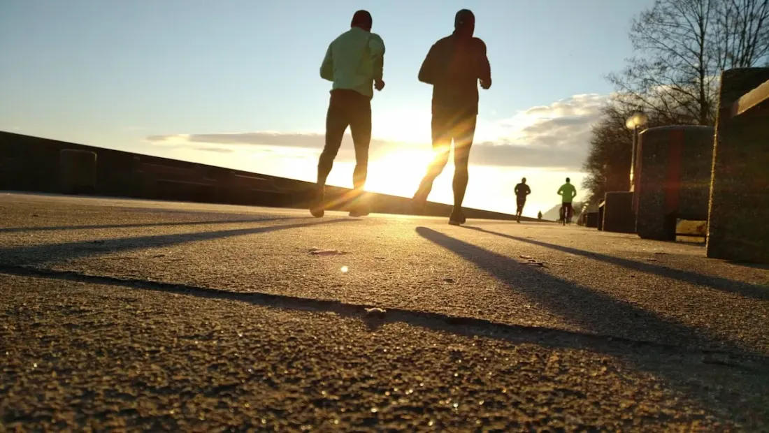 Runners at the start line of a race with red rock cliffs in the background