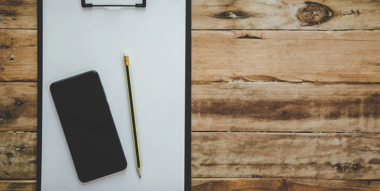 Organized desk workspace with laptop, notebook, and office supplies