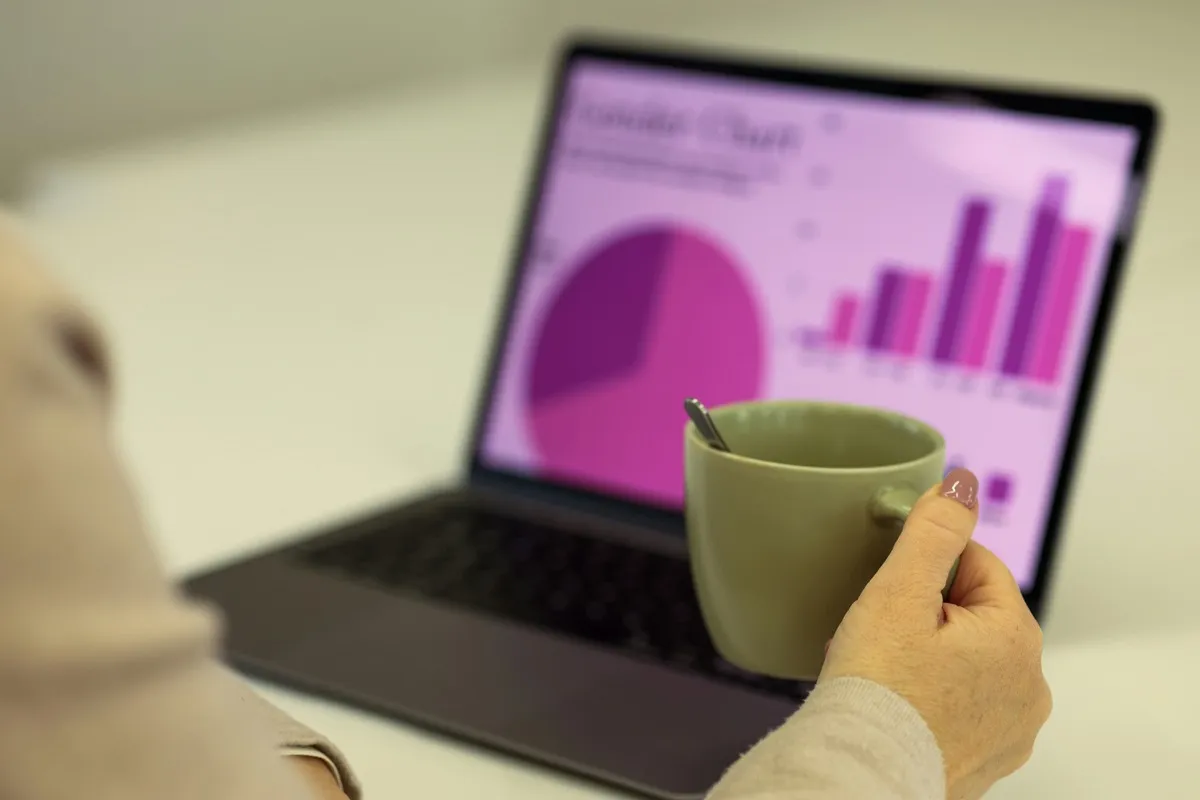 Laptop on a clean desk showing website analytics dashboard with a coffee cup nearby