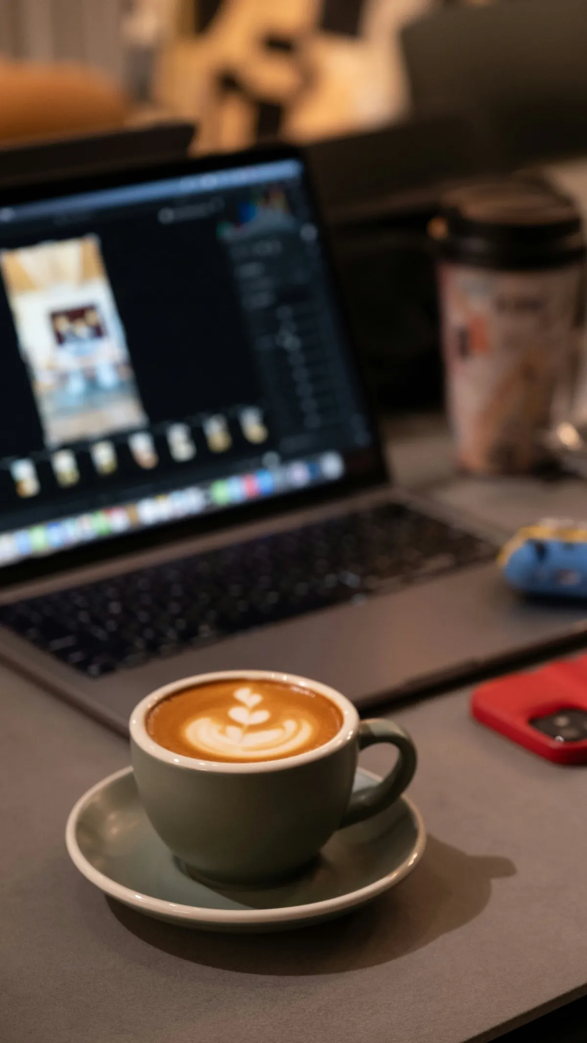 A laptop on a desk showing website analytics alongside a notebook and coffee cup