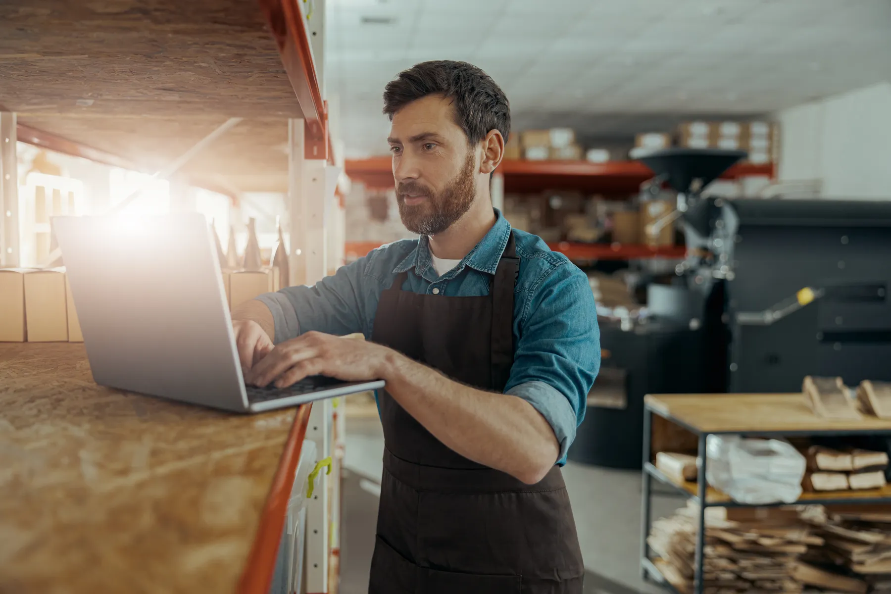 small business owner checking website on laptop in workshop
