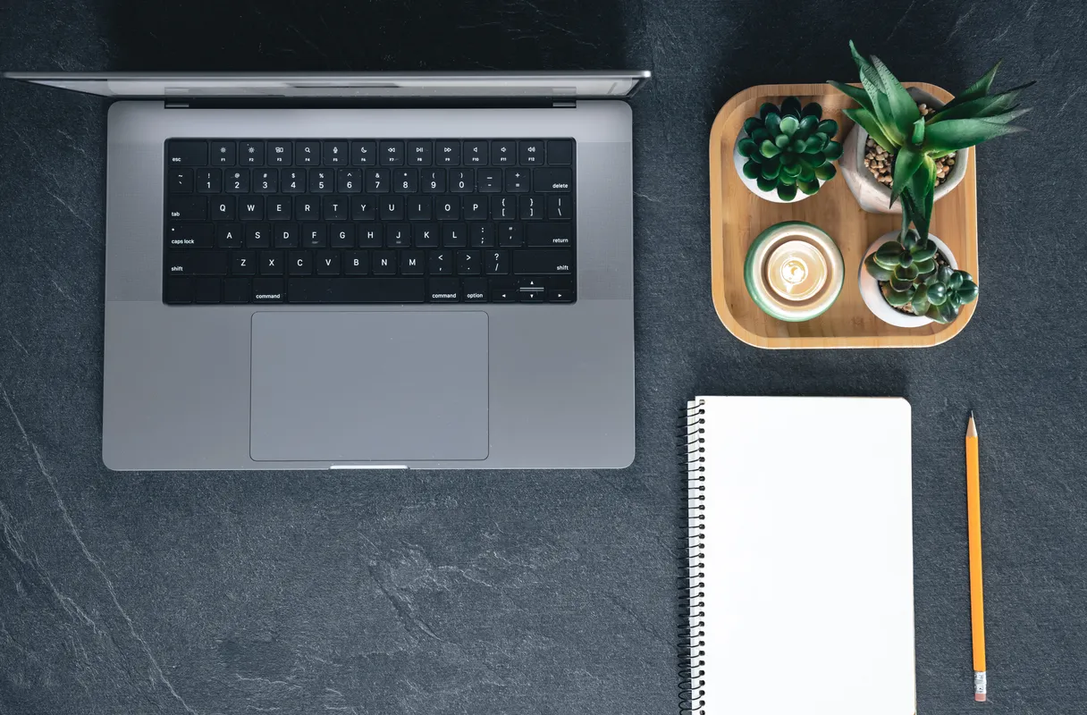 clean web design workspace with laptop, notebook, and coffee